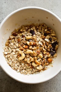 Combine oats, nuts, honey, coconut oil, cinnamon, and vanilla in a mixing bowl