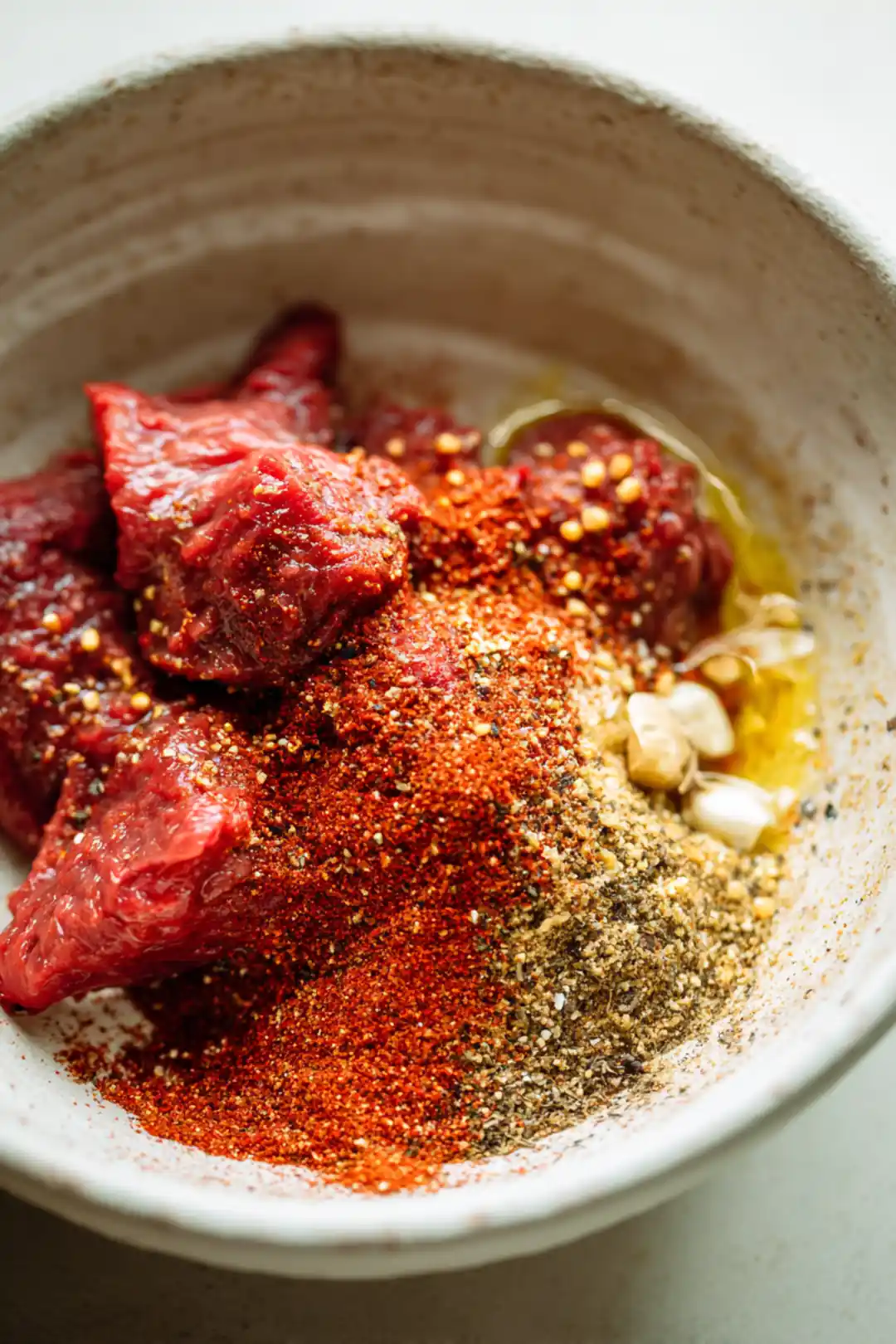 Combine olive oil, garlic powder, smoked paprika, and black pepper with steak tips to create a marinade