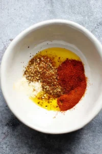 Combine olive oil, smoked paprika, cayenne pepper, and garlic powder to create a marinade