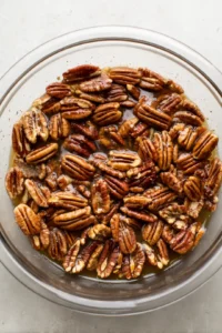 Combine pecan halves, maple syrup, cinnamon, and salt in a mixing bowl