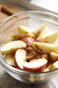 Combine sliced apples with cinnamon and sugar in a mixing bowl