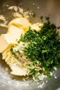 Combine softened unsalted butter, chopped parsley, minced garlic, salt, and black pepper in a mixing bowl