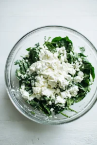 Combine spinach and feta cheese in a mixing bowl