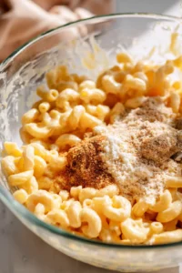 Combine the cooled macaroni and cheese with seasoning in a mixing bowl