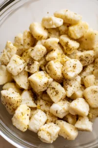 Combine the gnocchi with olive oil, salt, pepper, garlic powder, and dried herbs