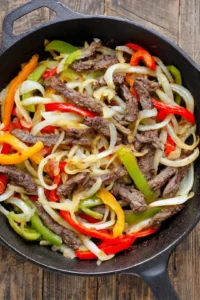 Cook the onion and bell pepper until soft, then add sliced beef and cook until browned