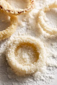 Dip onion rings into batter and coat with panko breadcrumbs