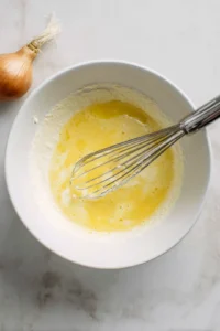 Dip the blooming onion in the batter and roll in breadcrumbs