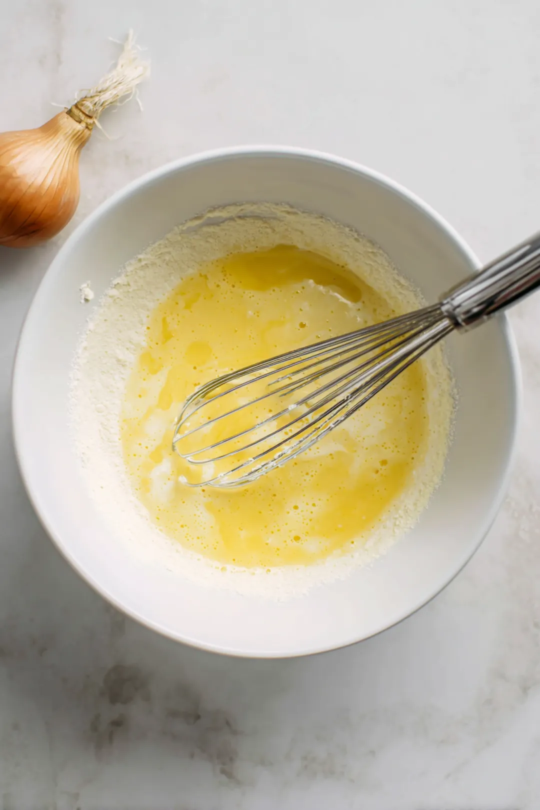 Dip the blooming onion in the batter and roll in breadcrumbs