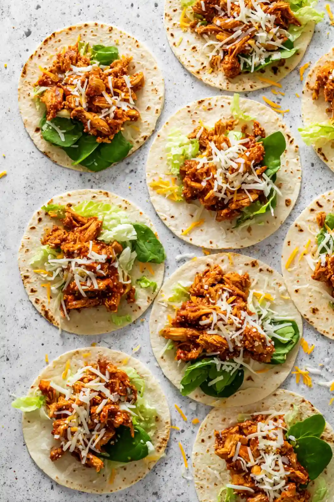 Distribute buffalo chicken mixture, lettuce, and shredded cheese on tortillas