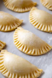 Fill dough circles with apple filling and crimp edges