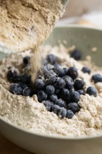 Gently fold in the blueberries and spoon the mixture into a greased muffin tin