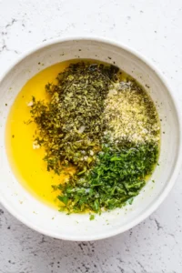 Mix marinade with lemon juice, parsley, oregano, garlic powder, and olive oil