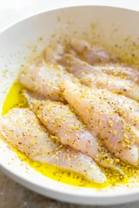 Mix tilapia fillets with olive oil and lemon pepper seasoning until evenly coated