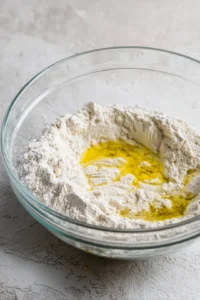 Mix together flour, yeast, water, and olive oil to form a smooth dough