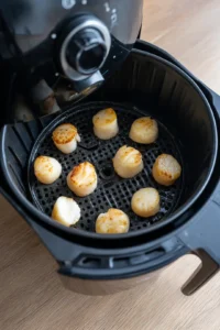 Place scallops in air fryer and cook until golden