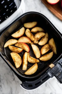 Place the apple slices in the air fryer and cook at 350 degrees Fahrenheit for 15 minutes, shaking the basket halfway through for even cooking