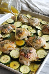 Place the chicken thighs and zucchini on a sheet pan, pour the marinade over the chicken and vegetables, ensuring everything is well coated, and bake for 25-30 minutes.