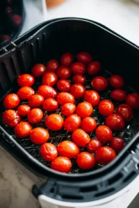 Place the coated tomatoes in the air fryer basket in a single layer and cook for 20-25 minutes until they are blistered and slightly charred.