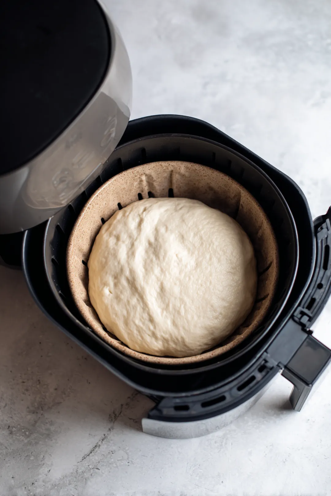 Place the covered bowl in the air fryer and allow it to proof for about 30 minutes, checking periodically to ensure it’s rising as expected.
