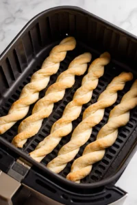 Place the rolled biscuit ropes in the air fryer basket