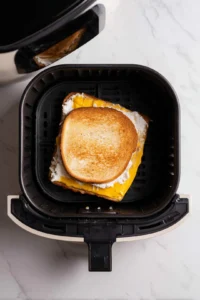 Place the sandwich in the air fryer and cook until golden and crispy