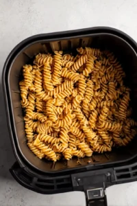 Preheat the air fryer and arrange seasoned pasta