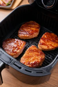 Preheat the air fryer to 375 degrees Fahrenheit and brush ham steaks with glaze