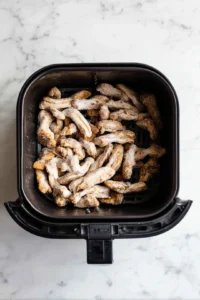 Preheat the air fryer to 375°F (190°C) and place the coated mushrooms in the air fryer basket in a single layer