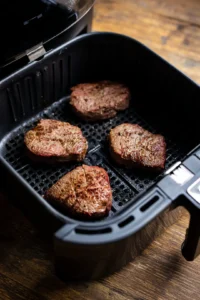 Preheat the air fryer to 380 degrees Fahrenheit and let steaks sit at room temperature