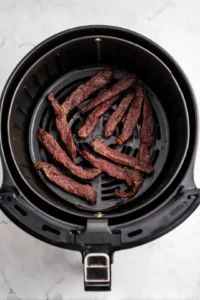 Preheat your air fryer to 160 degrees Fahrenheit and prepare beef jerky