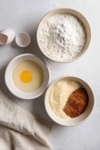 Set up a breading station with three bowls of flour, beaten egg, and seasoned panko breadcrumbs