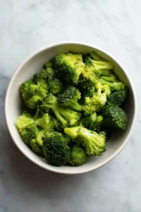 Steam broccoli florets until tender and chop finely