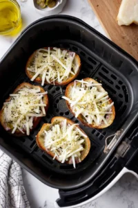 Top each sandwich with a slice of cheese and olive oil, then cook in air fryer until cheese is bubbly
