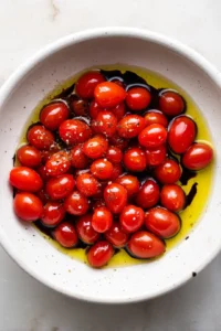 Toss cherry tomatoes with olive oil, salt, pepper, and balsamic vinegar