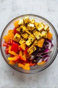 Toss cubed paneer, bell peppers, and onion in marinade and let sit for 15 minutes