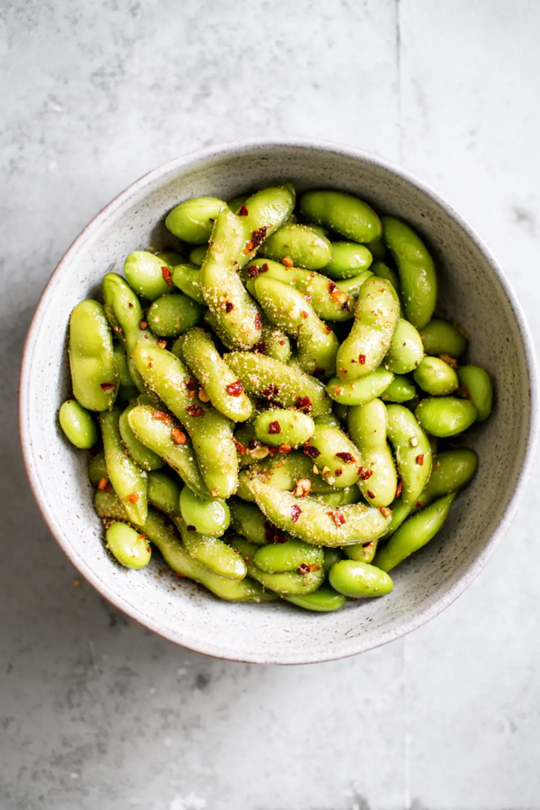 Toss frozen edamame with olive oil, sea salt, garlic powder, and red pepper flakes