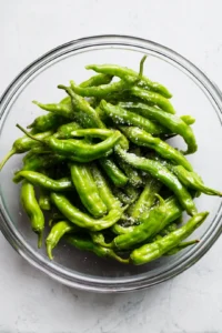 Toss shishito peppers with olive oil and sea salt