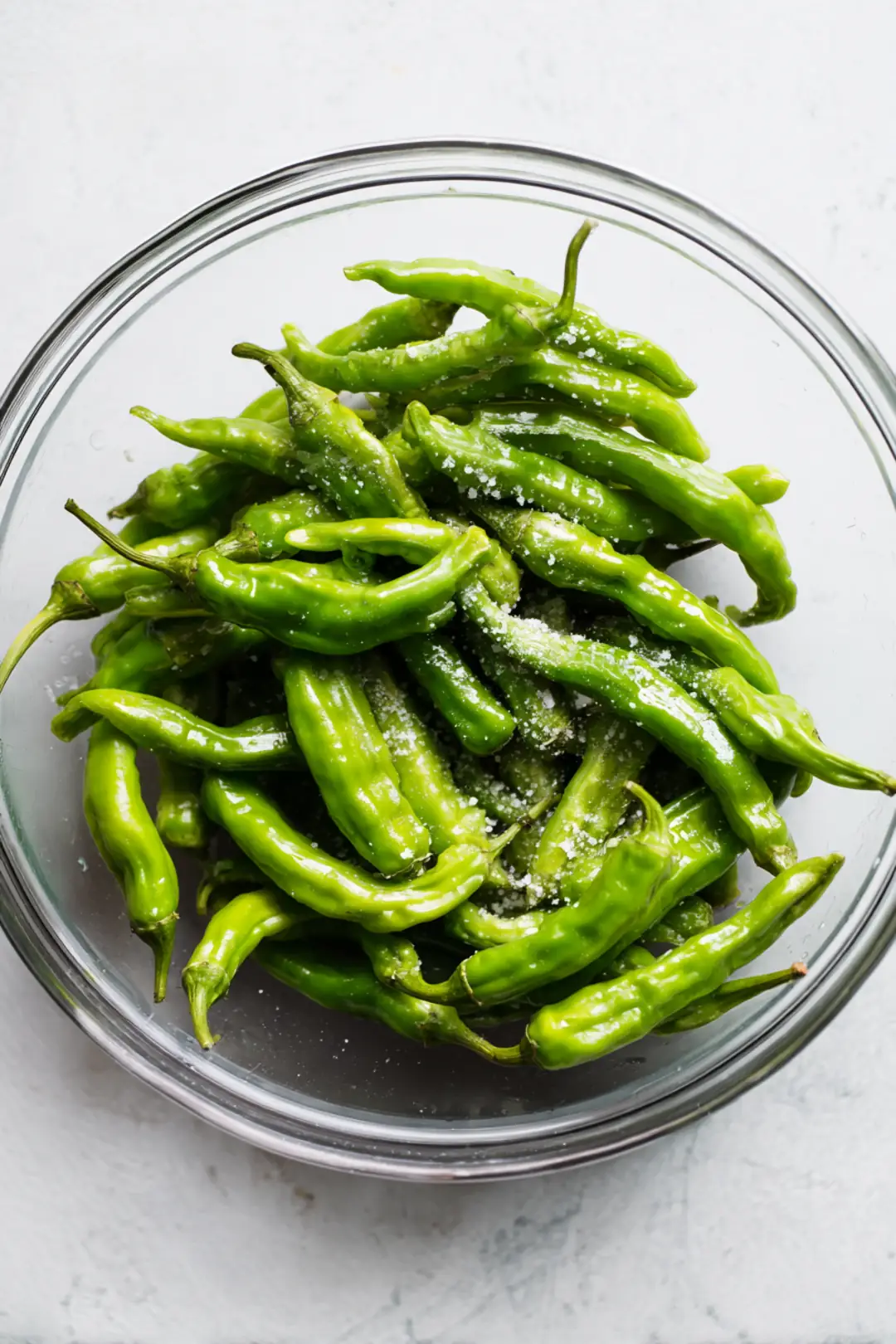 Toss shishito peppers with olive oil and sea salt