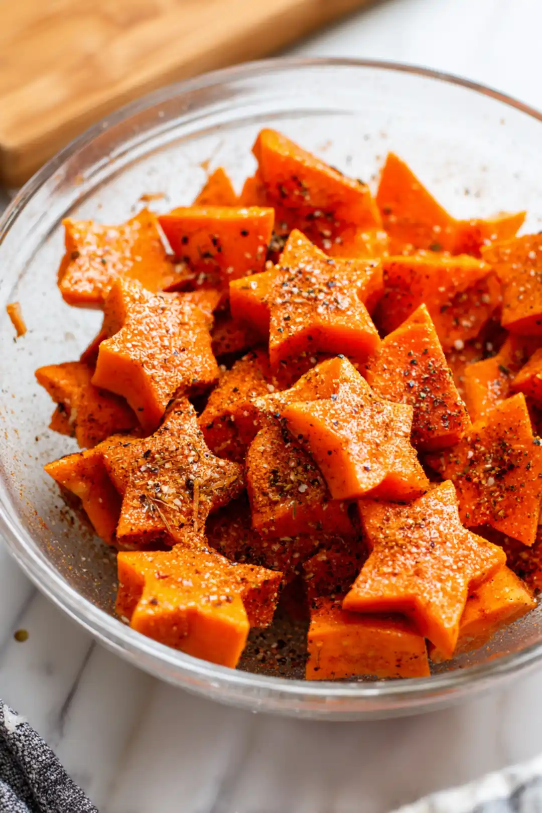 Toss star-shaped sweet potatoes with olive oil, garlic powder, paprika, salt, and black pepper