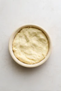 Transfer the dough into a small oven-safe dish and flatten the top gently