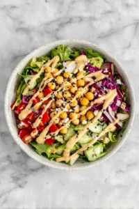 Add chickpeas to salad and drizzle with dressing