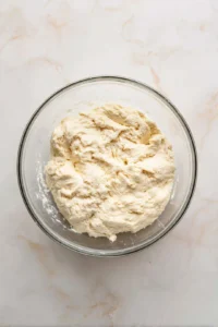 Add lukewarm water to the dough mixture