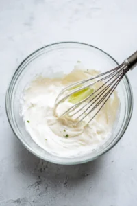 Apply sauce to grilled corn and top with Tajin and Cotija cheese
