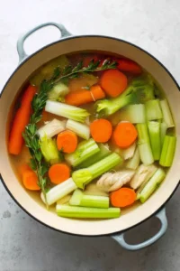 Combine chicken, water, celery, and carrots in a large pot and bring to a boil.