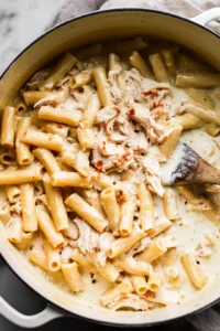 Combine cooked pasta with Alfredo sauce, chicken broth, shredded rotisserie chicken, mozzarella cheese, and Italian seasoning