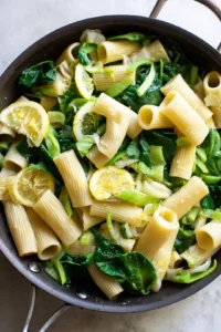 Combine cooked rigatoni with spring greens and lemon juice in skillet