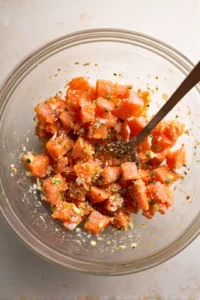 Combine diced salmon, olive oil, and furikake seasoning in a mixing bowl and toss gently