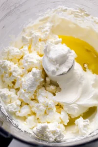 Combine feta cheese, cream cheese, olive oil, and lemon juice