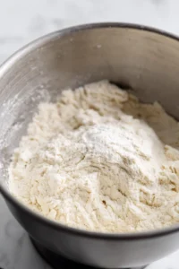 Combine flour, sourdough starter, and salt in a mixing bowl